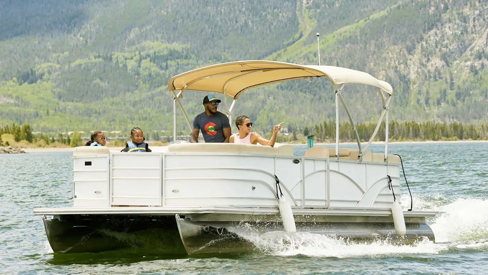 Famille à bord d'un ponton blanc sous bimini, sur un lac