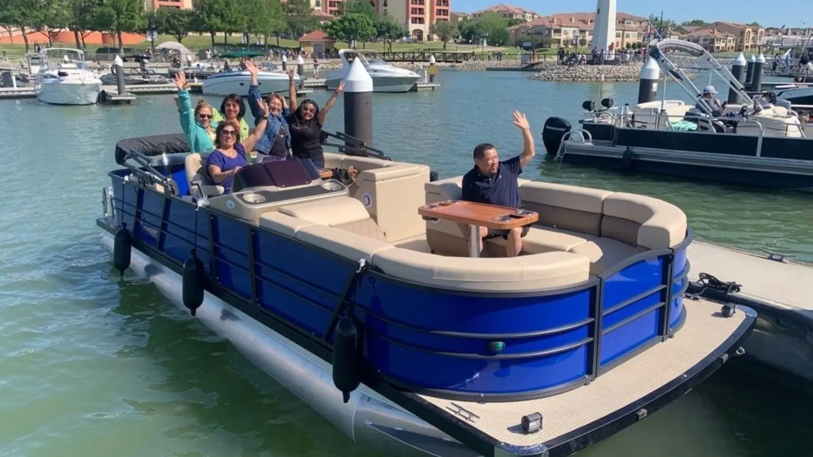 Groupe d'amis à bord d'un ponton bleu, au départ du port